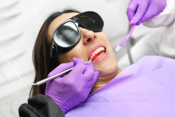 A patient wearing eye protection during a dental whitening appointment