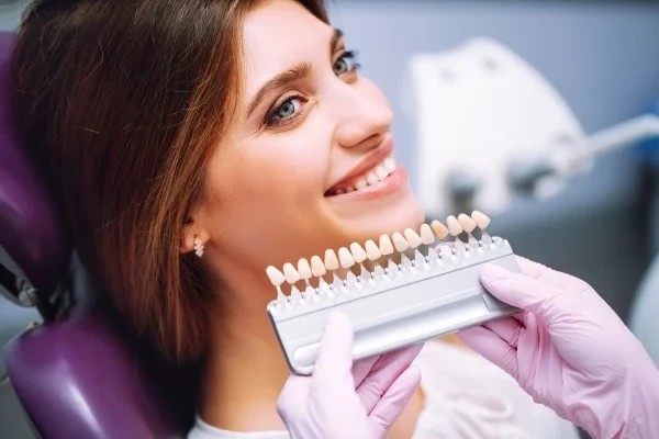 A patient comparing tooth shades at a dental appointment