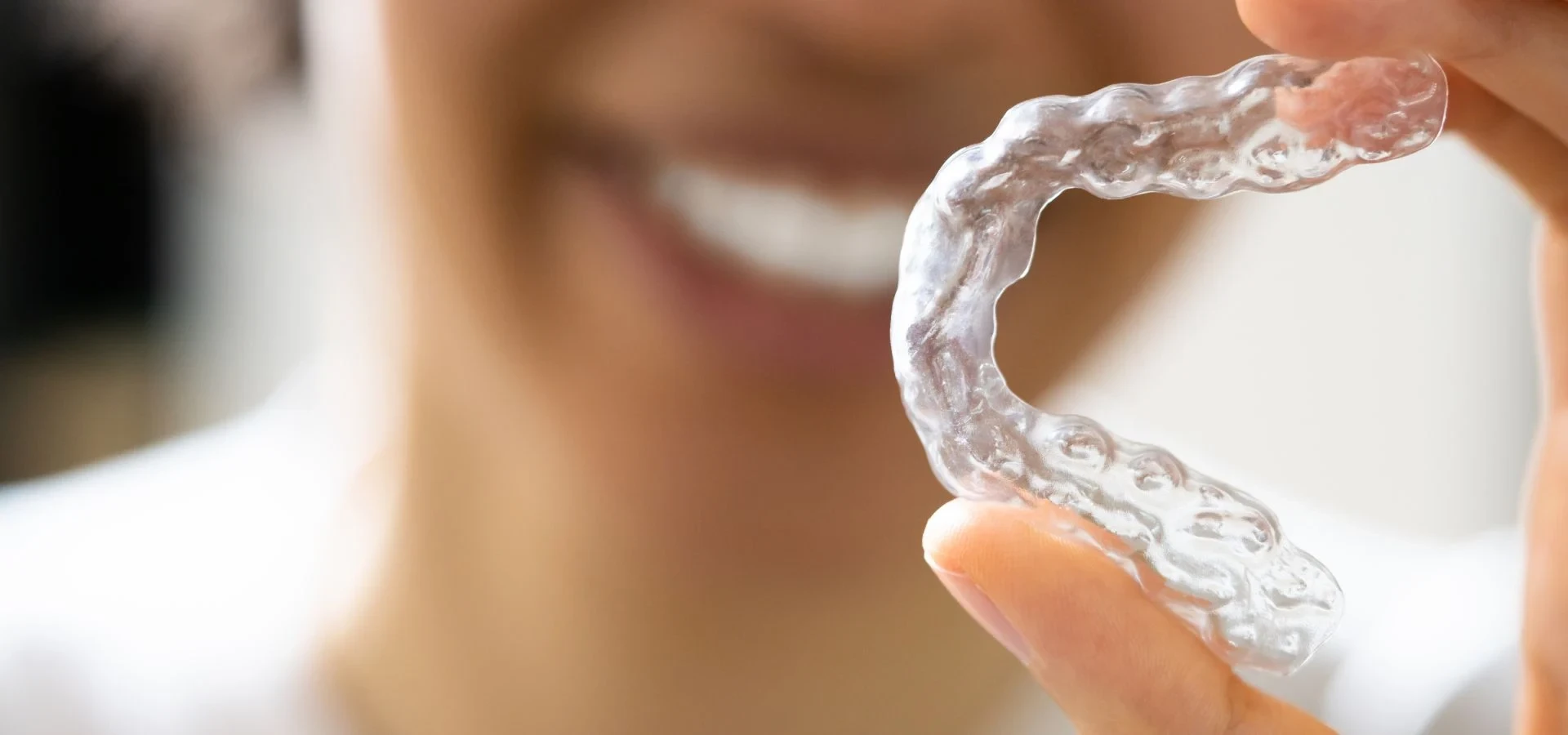A clear removable dental appliance held in a hand