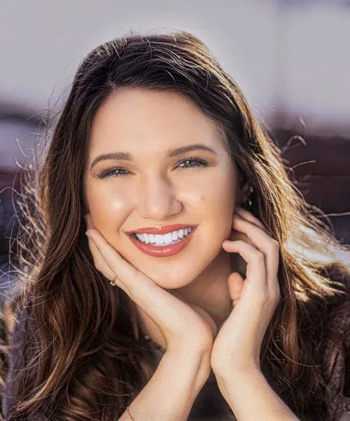 A smiling woman in the clinic’s smile design imagery