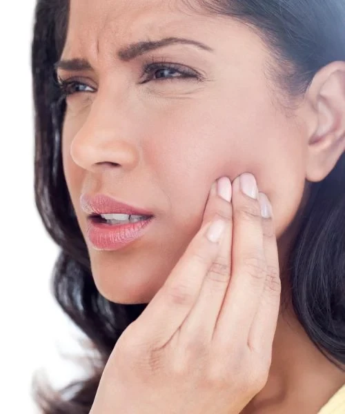 A woman touching the side of her jaw